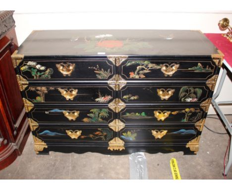 A Japanese style lacquered and gilt decorated chest,&nbsp;fitted eight drawers, having brass mounts raised on shaped apron an