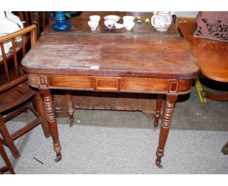 A 19th Century mahogany card table,&nbsp;raised on ring turned tapering supports terminating in castors, 92cm wide (in need o