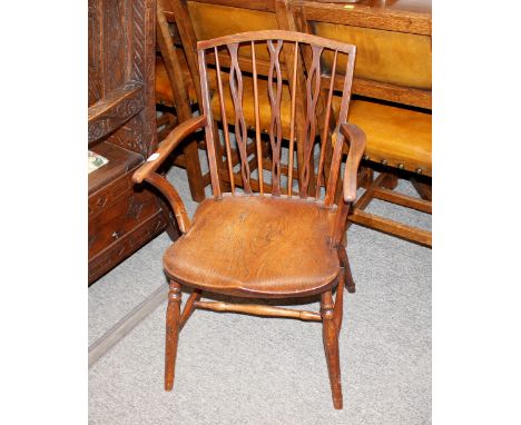 A 19th Century elm stick&nbsp;back elbow chair, the shaped seat raised on turned supports united by an H stretcher