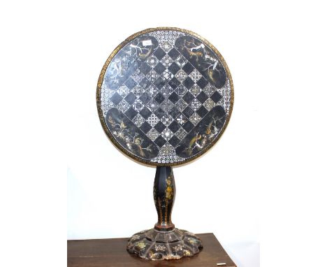 A Victorian papier maché and mother of pearl decorated tilt top chess table,&nbsp;raised on baluster column and segment circu