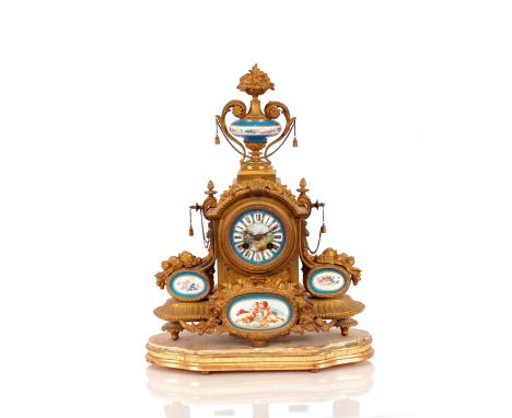 A 19th Century gilded and Sevres style porcelain panel decorated French mantel clock, surmounted by an urn finial, eight day 