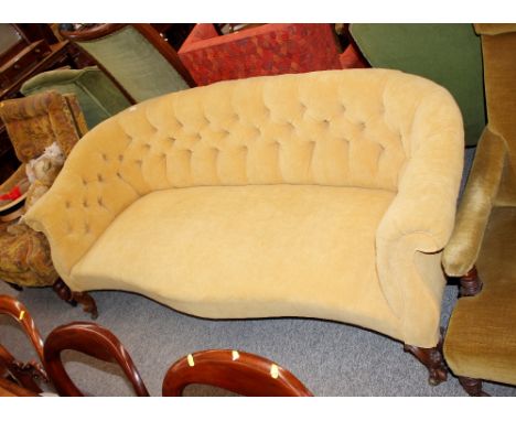 A Victorian walnut framed settee,&nbsp;of serpentine form, upholstered in gold button Dralon raised on carved cabriole suppor