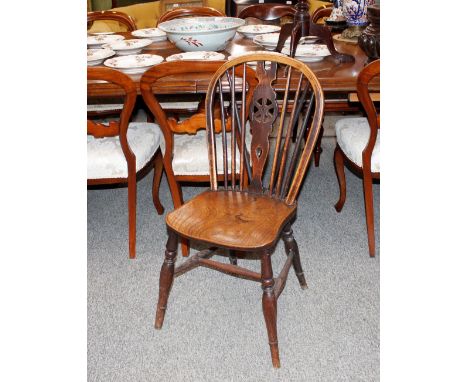 A set of four elm seated stick and wheel back dining chairs