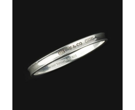 A silver bangle by Tiffany &amp; Co., the shaped polished bangle stamped to the front with 925 T &amp;Co 1837, hallmarked Lon