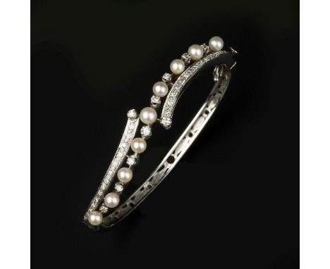 A cultured pearl and diamond bangle, the hinged bangle set with cultured pearls and eight cut diamonds, approximately 0.35 ca