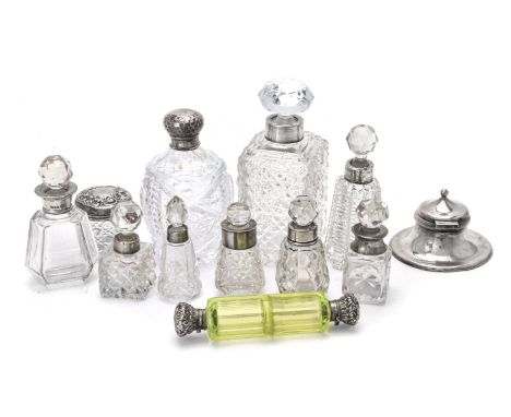 A collection of silver mounted items mainly scent or cologne bottles, including: a uranium double ended example, unmarked, 13