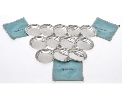 A set of twelve American silver coloured plain round dishes by Tiffany &amp; Co., 20th century, perhaps for butter, counters 