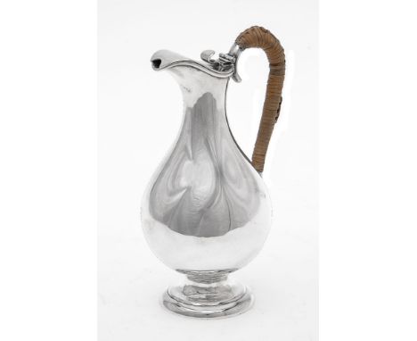 An Edwardian silver baluster ewer by Harman &amp; Co., London 1904, the hinged cover with a scroll thumbpiece, a wicker cover