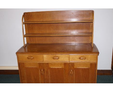 Ercol dresser of small proportion, incorporating two shelf plate rack, three apron drawers, double concertina action cupboard