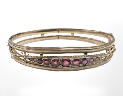A 9ct gold antique bangle set with graduated rubies, internally 6 cm x 5 cm. CONDITION REPORT: 8g.