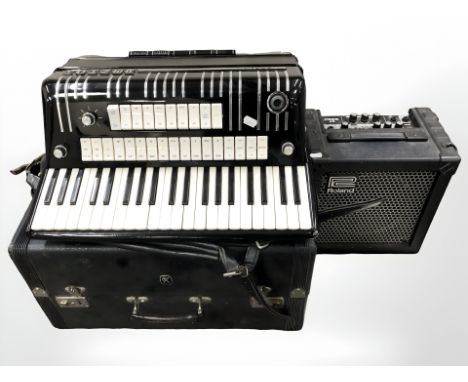 A Hohner Electravox Deluxe piano accordion, in carry case with instructions, and a Roland Cube 15 amplifier. 