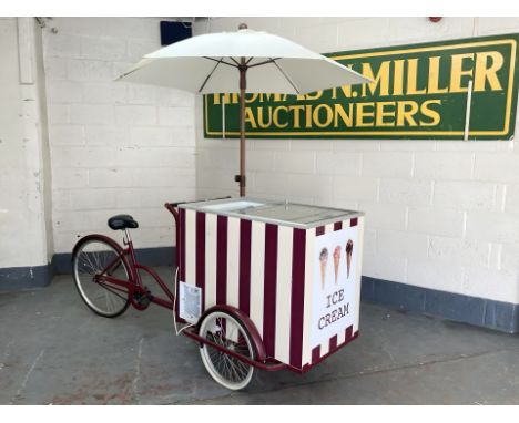 An ice cream vendor's traditional style tricycle with freezer and parasol