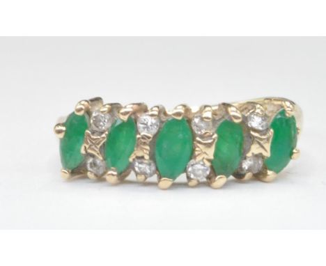 A hallmarked 9ct gold ring set with five marquise cut emeralds with eight alternate round cut diamonds. Hallmarked London 197