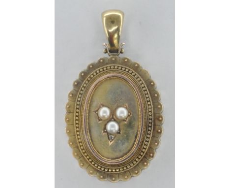 A 19th Century Victorian gilt metal locket of oval form having scalloped edges with beaded borders surround with a central fl