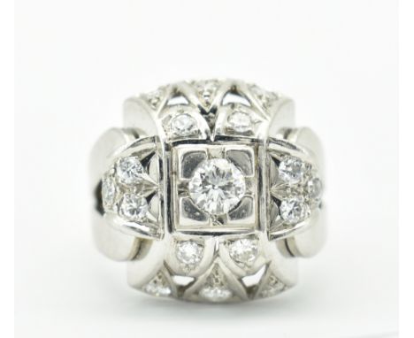 A French platinum and diamond bombe ring. The ring having a central round brilliant cut diamond to pierced domed head and bif