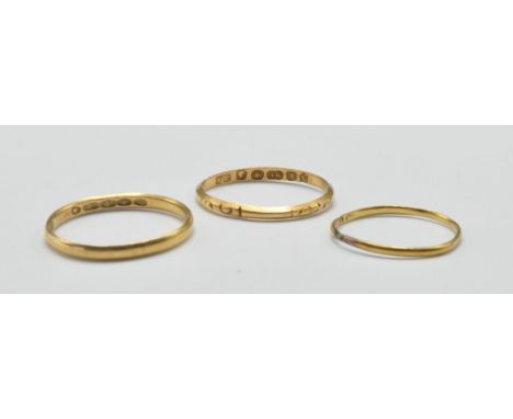 A group of three antique and later gold wedding band rings to include a hallmarked 22ct gold band ring (assay marked London, 