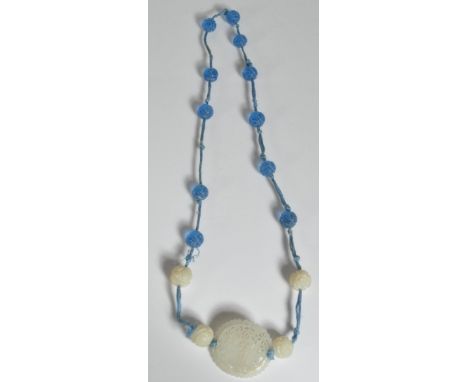 A Chinese jade and Peking glass strung necklace. The pierced jade bi roundel decorated with people and foliates having jade b
