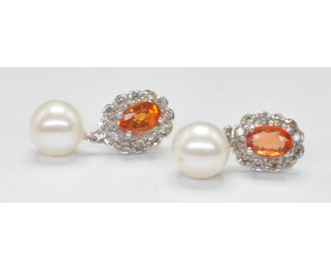 A pair of 9ct gold earrings set with an oval cut citrine set with a halo of round cut&nbsp; diamonds with cultured pearl drop
