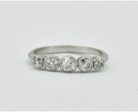 An 18ct white gold and diamond five stone ring. The ring set with 5 old cut diamonds in collet setting to plain tapering band