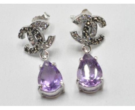 A pair of silver crossed C earrings set with pear cut amethyst drops, with marcasite's and white stones set to the heads. Bac