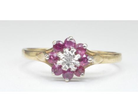 A hallmarked 9ct gold cluster ring set with a central illusion set diamond with a halo of round cut pink stones. Hallmarked B