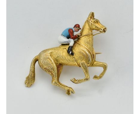 Horse Racing Interest. A 9ct gold and enamel brooch pin in the form of a jockey and race horse. The brooch having a textured 