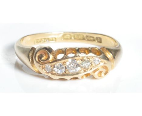 An 18ct gold and diamond 3 stone gypsy ring. the ring with 3 round brilliant cut diamonds to pierced head with scrolled ends,