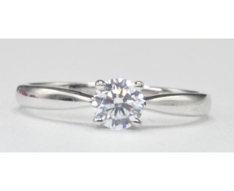 A 9ct white gold single stone solitaire ring. The ring with central round brilliant cut cz in basket mount to plain band ring