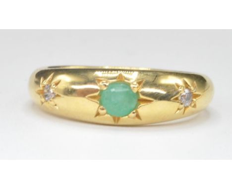 An 18ct gold emerald and diamond gypsy ring. The ring with central emerald flanked by 2 diamonds, all in star settings. The r