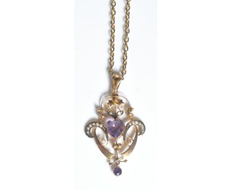 An early 20th century edwardian antique open work pendant having a central heart cut amethyst to the centre with a further ro