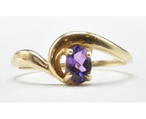 A 9ct gold ring set with an oval cut purple stone in a twist design mount. Assay marked Birmingham. Weight 1.9g. Size P.