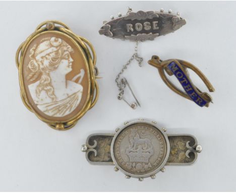 A group of four Victorian antiques brooches to include a silver brooch set with a George IV shilling coin, a wishbone brooch 