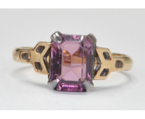 A 9ct gold and amethyst ring. The central cushion cut amethyst on silver setting to 9ct gold band ring. Stamped 9ct on silv s