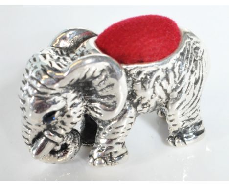 A stamped sterling silver pin cushion in the form of an elephant with engraved features and red felt cushion to the back. Sta