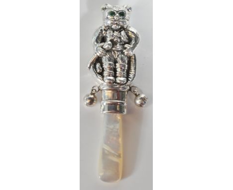 A stamped sterling silver baby rattle in the form of a mouse in men's clothing with green glass eyes and bells either side, u
