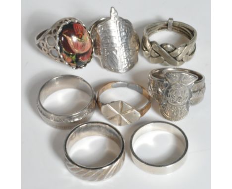 A collection of silver and white metal rings to include coin ring, band rings, armorial head rings, stone set, keepers ring e