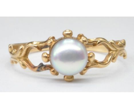 A 20th Century antique yellow gold and pearl ring set with a central pearl with pierced decoration shoulders. Gold unmarked, 