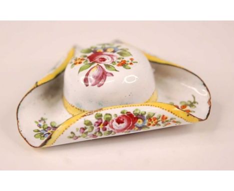 A late 19th century enamel patch box in the form of a tricorn hat, the white ground decorated with yellow bands and floral sp