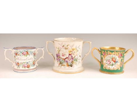 A Victorian soft-paste porcelain loving cup, enamel decorated with a floral reserve within gilt borders and on a green ground