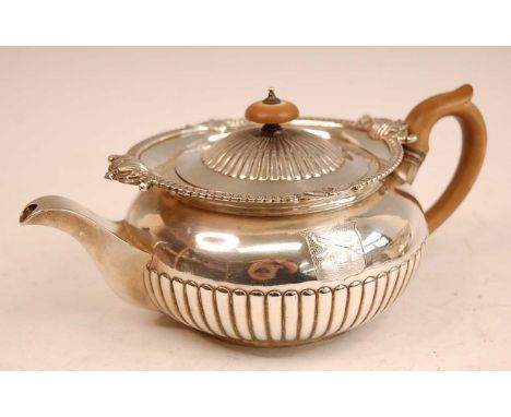 A George III silver teapot, of half-reeded circular squat form, having bright cut engraved armorial, walnut handle, 21.7oz, m