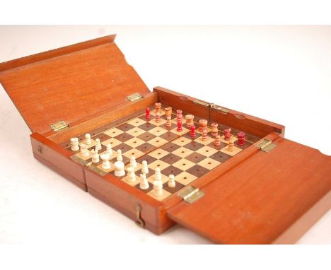 A circa 1900 mahogany travelling chess set, having fold-out action opening to reveal rosewood and satinwood veneered playing 