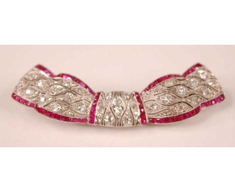 An Art Deco style white metal, ruby and diamond swag shaped bar brooch, comprising 81 Old European and rose cut diamonds in g