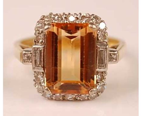 A 18ct yellow and white gold, topaz and diamond rectangular cluster ring, comprising a centre step cut orange topaz within a 