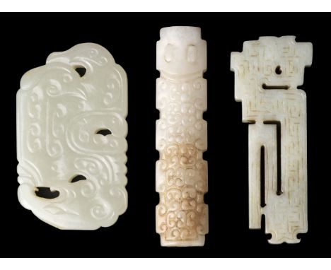 * Jade. A Chinese white jade toggle, carved with geometric decoration, 7.5 cm long, together with two carved jade panels, 6.5