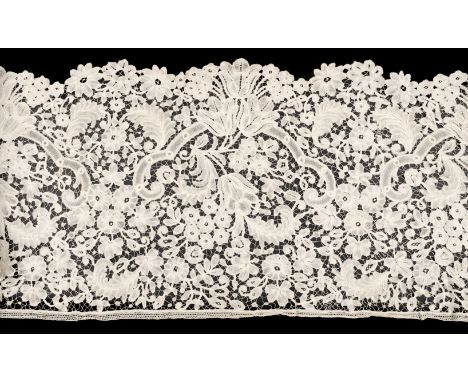 *Lace. A large length of Bruges bobbin lace, 19th century, cream lace flounce, hand-worked with large tulips and other flower