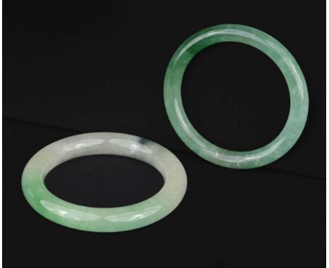 * Jade. A Chinese jade bangle, apple green colour, 8 cm diameter, together with a similar bangle, 7 cm diameterQTY: (2)