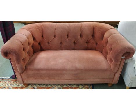 A 20th century two seater club settee with pink button back upholstery on turned feet, 75cm high x 165cm wide x 95cm deep Con