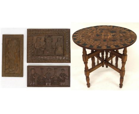 A 20th century circular occasional table with top carved Mayan pictographs on turned folding base, 72cm high x 78cm diameter 