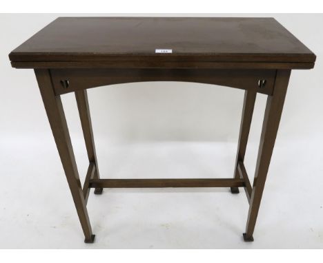 A 20th century mahogany arts &amp; crafts fold-over card table with pierced friezes on stretchered square tapering supports, 