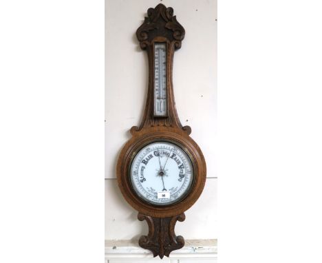 A Victorian carved oak banjo form barometer/thermometer Condition Report:Available upon request